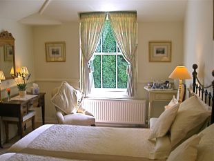 B&B accommodation twin bedroom. Guests occupying the twin bedroom have exclusive use of the beautifully hand painted private bathroom and private landing. Both rooms have views across pretty courtyard, gardens and south facing sun terrace