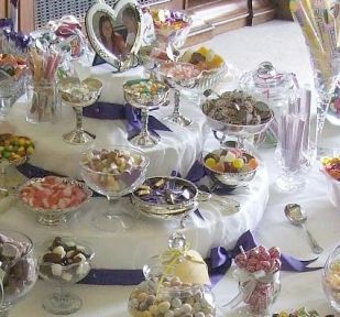 Close-up of cake-style centrepiece on table.  Yours will be trimmed with your colours. The photo is optional, you can have more sweets up there if you prefer.
