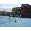 Mike organising mini-tennis coaching on the front court.