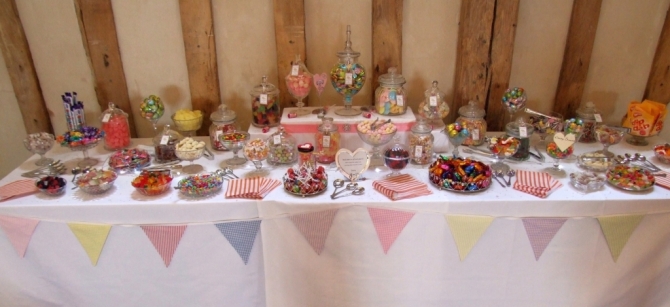 Wedding sweets and candy table for 100 guests on a 12' long table decorated with bunting.