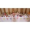 Wedding sweets and candy table for 100 guests with 26 varieties on a 12' long table decorated with bunting.