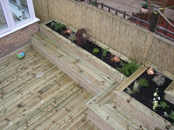 Decking with storage for childrens toys doubles as seating www.heysgroundcare.co.uk
